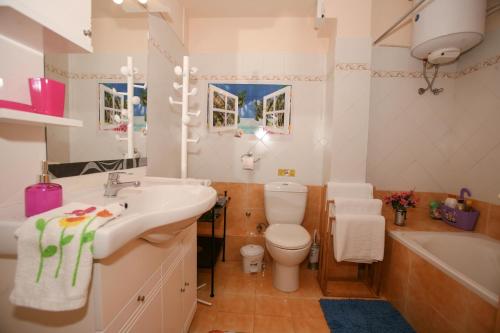 a bathroom with a sink and a toilet and a tub at Tritsa House, 3-bedroom apt next to Corfu Town and airport in Corfu Town