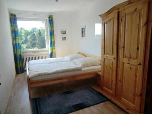 um pequeno quarto com uma cama e uma janela em Ferienwohnung Kehmeier em Polle