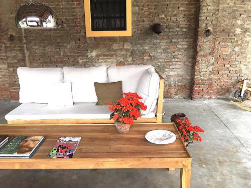 a white couch with flowers on a coffee table at La Fornace in Alessandria