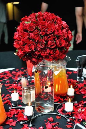 a vase with a bouquet of red roses on a table at Umthunzi Hotel and Conference in Umtentweni