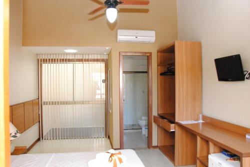 a room with a bedroom with a toilet and a ceiling fan at Pousada Cambucá de Cabo Frio in Cabo Frio