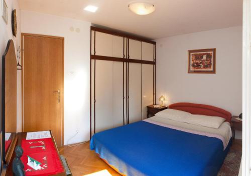 a bedroom with a blue bed and a closet at Apartment Nevica in Split