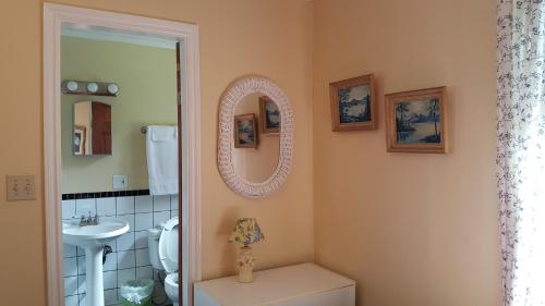 a bathroom with a sink and a toilet and a mirror at Woodside Inn in Harrison Mills