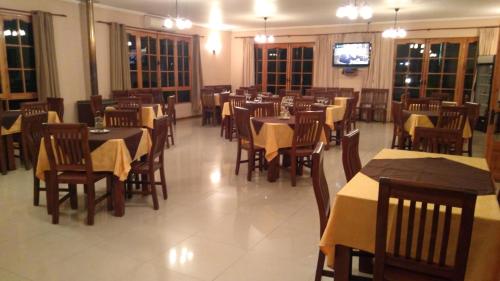 a dining room with tables and chairs and a television at Hotel Punakora Aconcagua in San Felipe