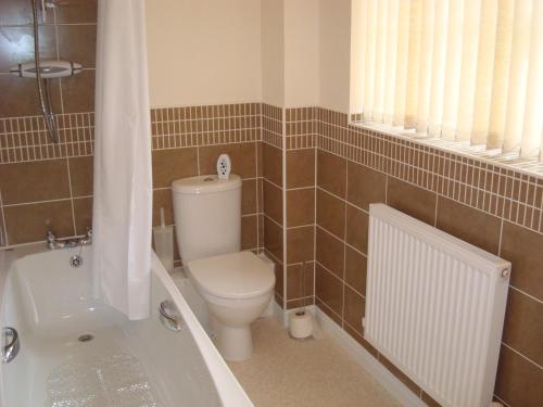 e bagno con servizi igienici e vasca. di At home in the city serviced apartments Newport a Newport