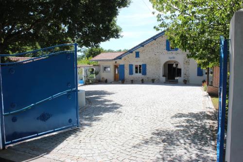 an entrance to a house with a blue gate at Chambre d'Hôtes au Sargaillon in Pouillon