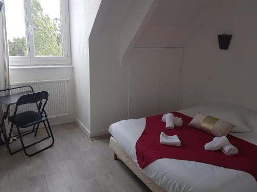 una camera con un letto e una sedia e una finestra di Auberge Le Guinefort a Léhon