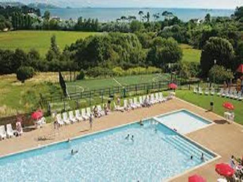 a large swimming pool with chairs and umbrellas at 2 Bed Static Caravan @ Hoburne Devon Bay in Paignton
