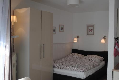 ブラウンラーゲにあるHarz-Zauberのベッドルーム1室(ベッド1台、白いキャビネット付)