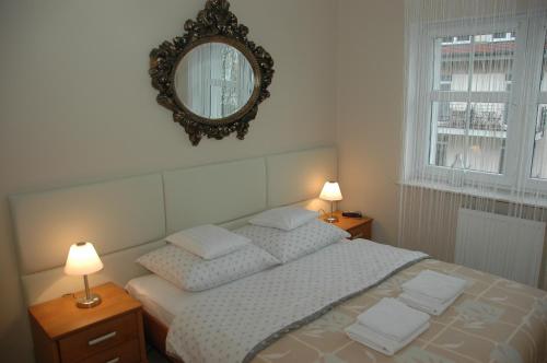 a bedroom with a bed with two lamps and a mirror at Apartament Przy Promenadzie in Świnoujście