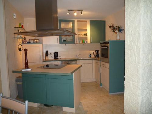 a kitchen with green cabinets and a blue island at Zum alten Seemann in Pruchten