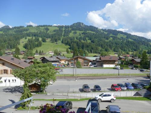 a parking lot with cars parked in front of a mountain at Hotel Kernen in Gstaad