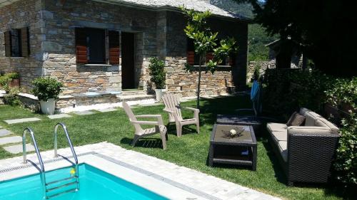 a backyard with a pool and chairs and a house at Pacithea Villas in Miléai