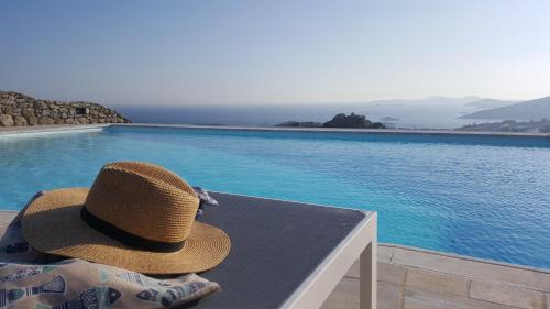 a hat sitting on a table next to a swimming pool at Otherview Villa in Super Paradise Beach