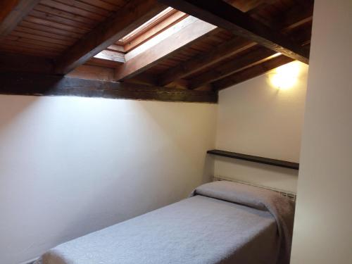 una camera con letto in una stanza con soffitti in legno di Villino "Il Rustichetto" a Genova