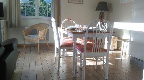una sala da pranzo con tavolo e 2 sedie di Chambre d'Hotes Les Hortensias a Rang-du-Fliers