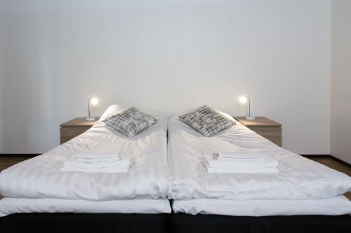 a white bed with two pillows on top of it at Hotelli Salpa in Luumäki