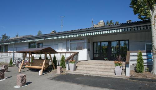 a building with a picnic table and a bench at Hotelli Salpa in Luumäki