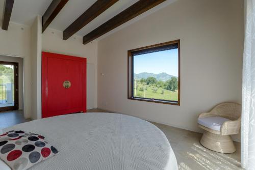 a bedroom with a large bed with a red door and a window at Casa delle More in Civitaquana