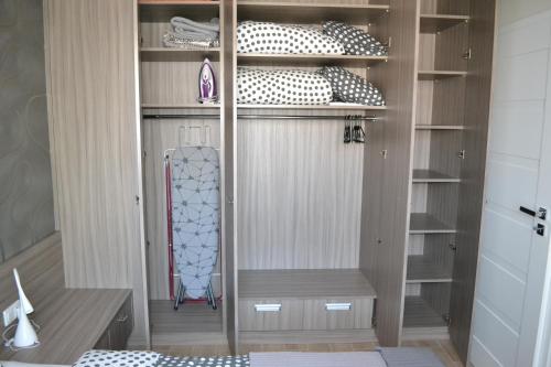 Zimmer mit einem Schrank und Holzregalen in der Unterkunft Apartament New Gdynia in Gdynia