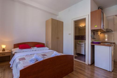 a bedroom with a bed with red pillows on it at Apartment Riva 5 in Komiža