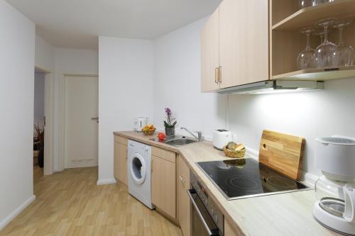 uma cozinha com uma máquina de lavar roupa e uma máquina de lavar roupa em Berlin City Apartments em Berlim