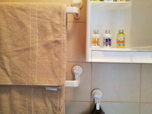 a bathroom with a towel and two bottles of alcohol at Mia Airport studio apartment in Velika Gorica