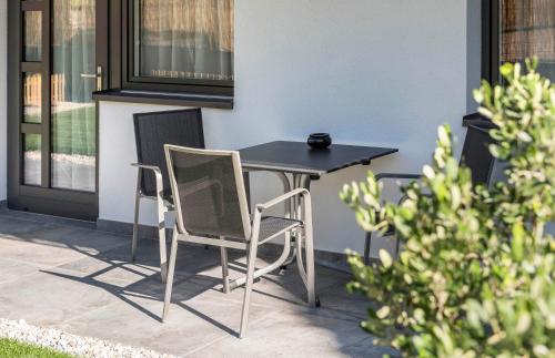 a black table and two chairs on a patio at Apartment Zielspitz in Parcines