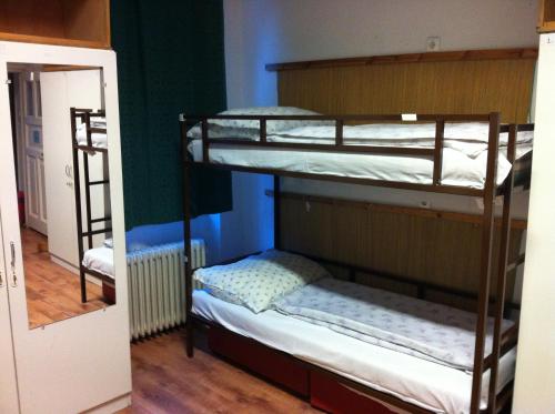 two bunk beds in a room with a hallway at Season Hostel in Budapest