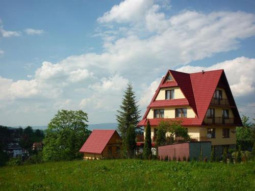 a house with a red roof on top of a hill at U Małgorzaty in Bukowina Tatrzańska