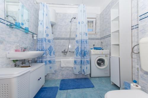 a bathroom with a sink and a washing machine at Apartments Katic in Trogir