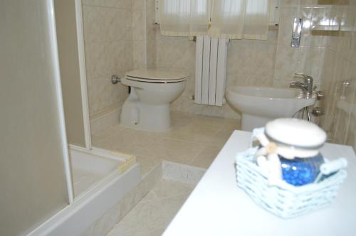 a bathroom with a toilet and a tub and a sink at La Casetta delle Rose in San Donato