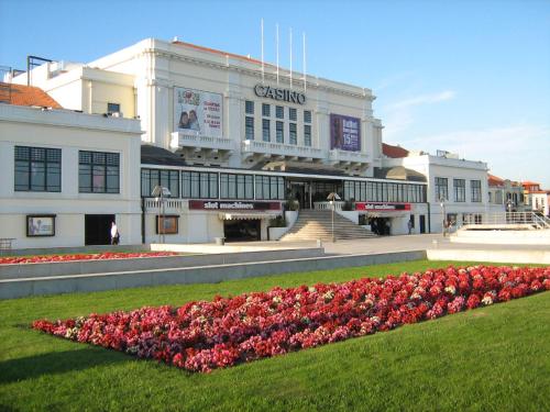 a building with a bunch of pink flowers in front of it at Vasco da Gama in Póvoa de Varzim
