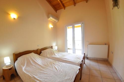 a bedroom with a bed in a room with a window at Corfu Villa Ermioli with Pool in Giannádes