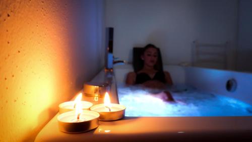 a woman laying in a bath tub with candles at B&B Verzavò in Cetraro