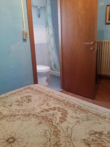 a bedroom with a bed and a bathroom with a toilet at Azzurre BeB in Laterina