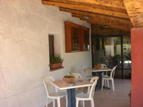 two tables and chairs in front of a building at Hotel Turismo Rurale Montitundu in Marina di Portisco