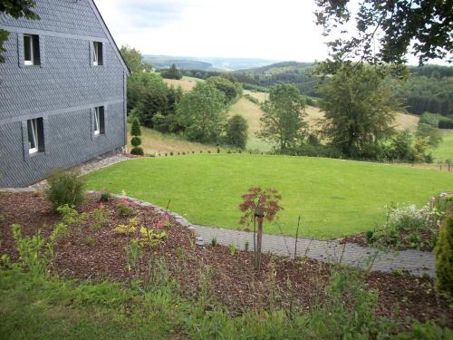 a house with a field next to a building at FILD - Holiday Apartment in Saint-Vith