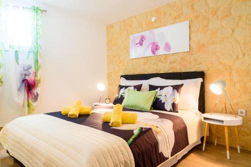 a bedroom with a large bed with yellow pillows at Villa Lucija Bol in Bol