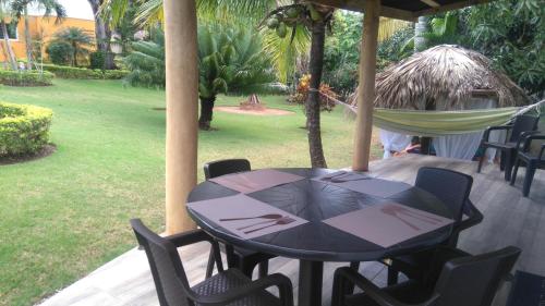 a black table and chairs on a porch with a hammock at Villa Victoria in Sosúa