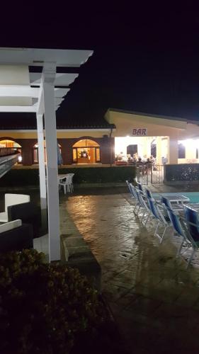 a group of chairs sitting next to a pool at night at Hotel La Fattoria Sul Mare in Capo Vaticano