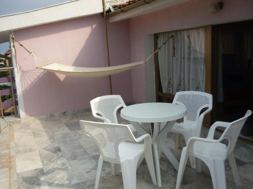 a table and chairs and a hammock on a patio at Hotel Strajica in Lozenets