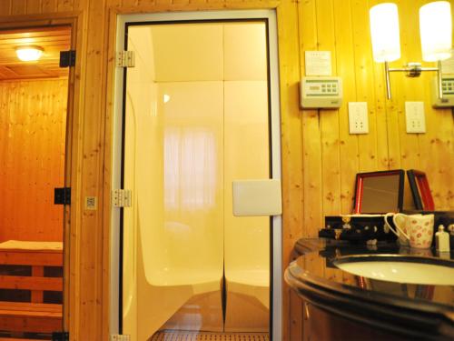 a bathroom with a glass shower and a sink at Grand Metropark Wanshi Hotel Taiyuan in Taiyuan