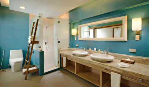 a bathroom with two sinks and a mirror at Mithi Resort & Spa in Panglao Island