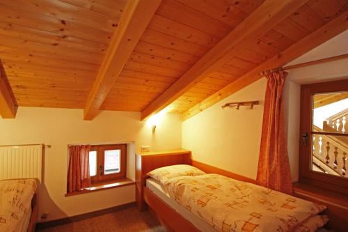 a bedroom with two beds and a window at Unterbergerhof in Val di Vizze