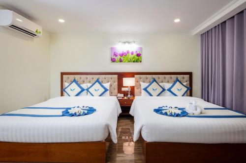 a hotel room with two beds with blue and white at Apus Hotel in Nha Trang