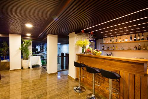 a bar with black stools in a room at Apus Hotel in Nha Trang