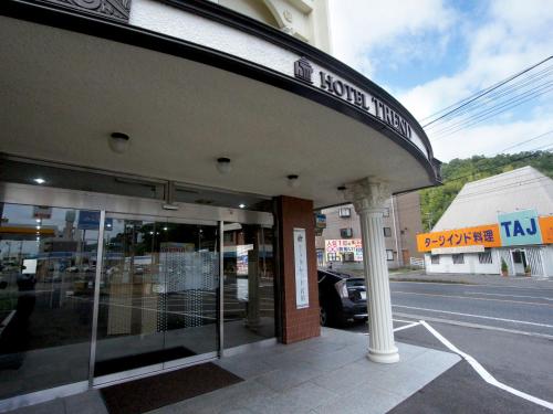un edificio con un letrero al lado de una calle en Hotel Trend Iwakuni, en Iwakuni