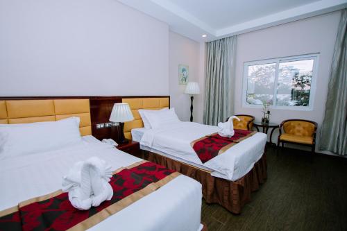 a hotel room with two beds with towels on them at Palawan Uno Hotel in Puerto Princesa City