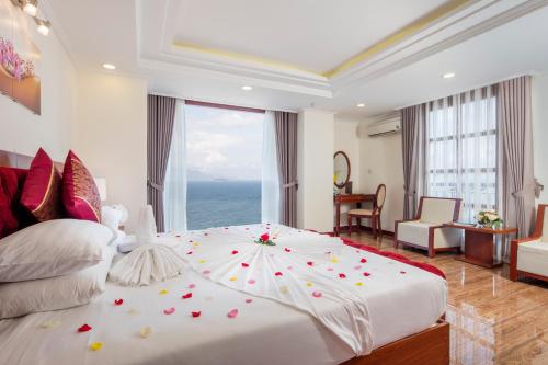 a bedroom with a large white bed with flowers on it at Apus Hotel in Nha Trang